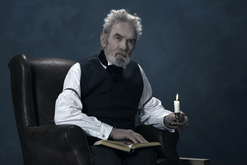 Alert Dickens Scrooge Man Sitting in Chair with Book Holding Can