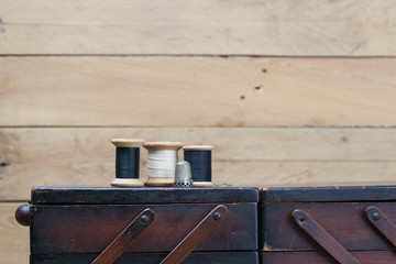 Nähgarn und Rollen mit Faden auf alter Holz Box zur Aufbewahrun