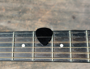 Guitar pick on finger board.