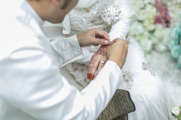 Obraz na płótnie Canvas the groom put a wedding ring to the bride hand. shallow dof. sel