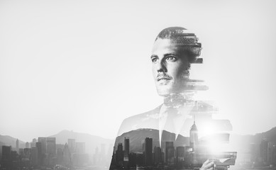 BW multiexposure of young businessman and sunrise in contemporary city on the background