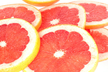 Fresh grapefruit rings on white background