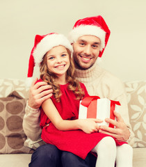 smiling father and daughter holding gift box