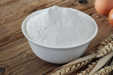 Flour in a bowl close up on wooden table
