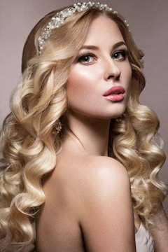 Beautiful blonde in a wedding image with curls, light lips and tiara. Beauty face.