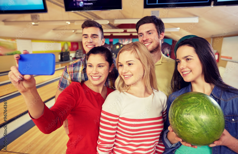 Poster happy friends with smartphone in bowling club