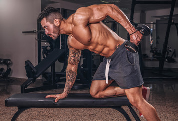 Handsome muscular man exercise in the gym.