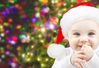 happy baby in santa hat over christmas lights