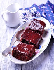 chocolate brownie cake on a vintage platter on a gray background. Rustic style. Selective focus.