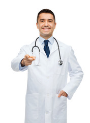 smiling male doctor in white coat pointing at you