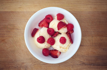 Bowl of vanilla ice cream with raspberries