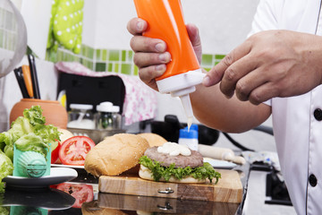 Chef putting mayonnaise on the Hamburger bun