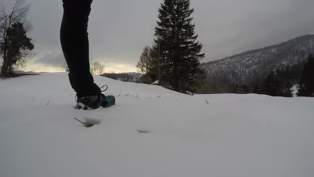 Man walking in snow at sunset