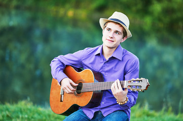 man playing acoustic six string guitar