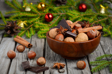 Hazelnuts and walnuts with chocolate and cinnamon in a wooden bowl. 