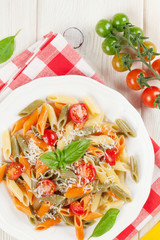 Colorful penne pasta with tomatoes and basil