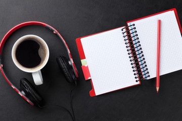 Fototapeta na wymiar Desk with notepad, coffee and headphones