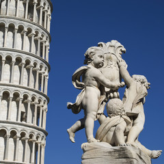 Fototapeta na wymiar Leaning Tower of Pisa with a statue in foreground