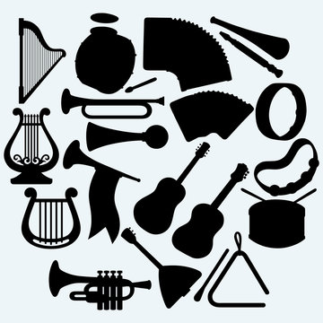 Different music instruments. Isolated on blue background. Vector silhouettes