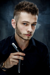 Elegant young handsome man. Studio fashion portrait.Portrait of a young brutal man with straight razor