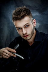Elegant young handsome man. Studio fashion portrait.Portrait of a young brutal man with straight razor