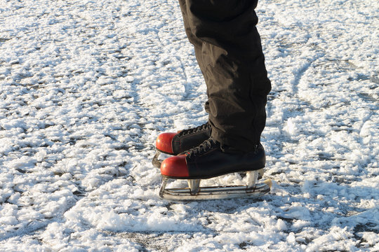 Male feet in the skates on a snow surface of the river
