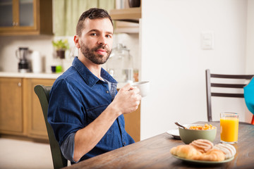 Young man enjoying breakfast at home