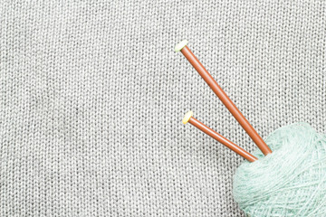 Grey knitted fabric made of heathered yarn with knitting forks a