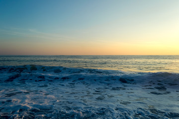 Waves breaking on a stony beach, forming sprays