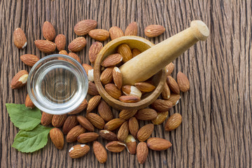 Almonds seed and almond oil on wooden background