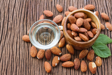 Almonds seed and almond oil on wooden background