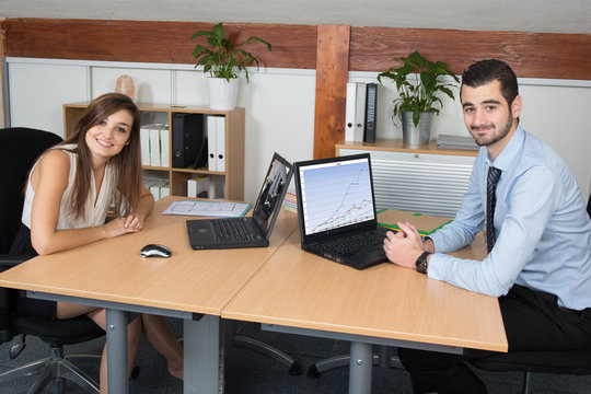 Portrait of two busy young people working in a call center