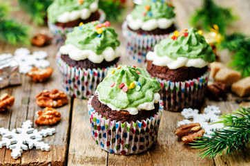 Chocolate cupcakes with green frosting and sprinkles on holiday