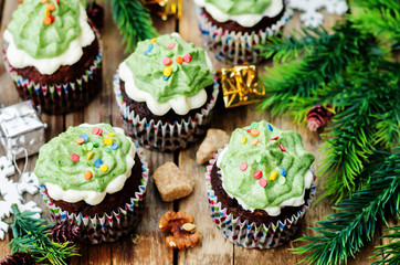 Obraz na płótnie Canvas Chocolate cupcakes with green frosting and sprinkles on holiday