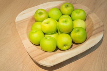 Green apples in wooden tray