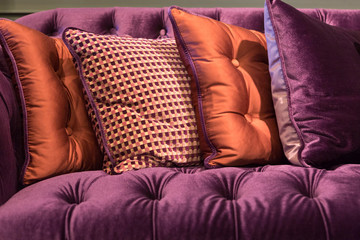Close up of violet velvet sofa and cushions