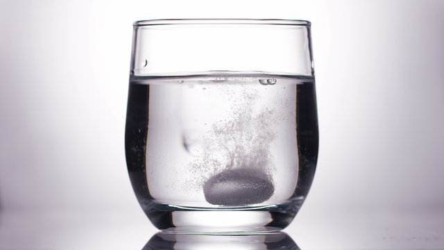 4KEffervescent tablet dropped into a glass of water, in slow motion