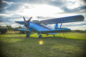 old airplane on green grass and sunset background