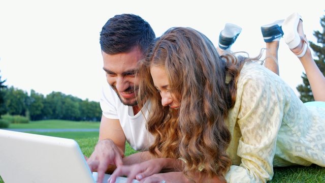 Young couple playing in games on laptop.