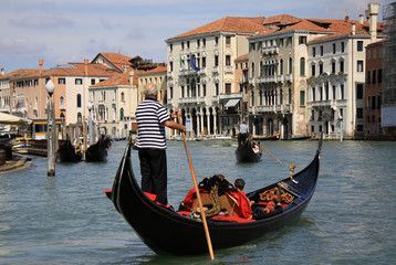 VENICE, ITALY - SEPTEMBER 02, 2012:  Gondolier rides gondola on Grand Canal in Venice - obrazy, fototapety, plakaty