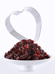 A bowl with dried cranberries and the silhouette of a heart