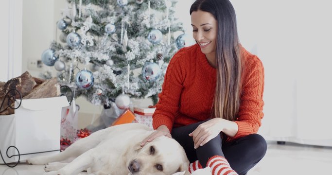 Laughing young woman with her dog at Christmas