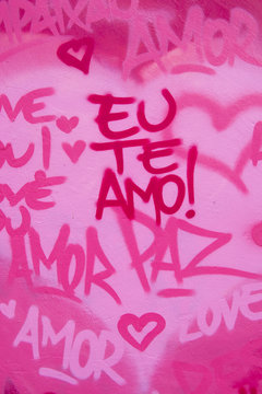 International love and peace graffiti in English and Brazilian Portuguese writing on pink wall in Rio de Janeiro, Brazil [English translation: I love you]
