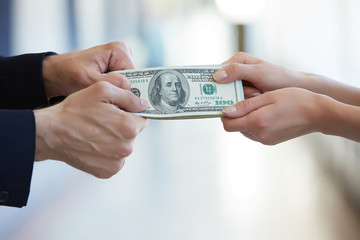 business woman and a businessman hold money