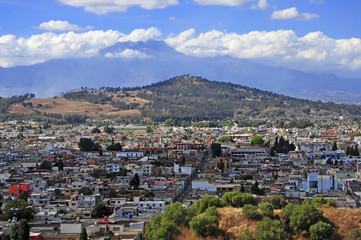 Fototapeta na wymiar Characterized by its vibrantly colored buildings and narrow streets, Puebla is a popular spot for tourists, despite being built under multiple active volcanoes. 