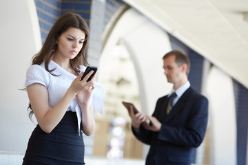 business woman with a telephone and a businessman with a tablet