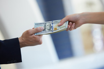 business woman and a businessman hold money