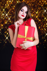 Pretty girl is wearing red dress with gift box 