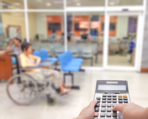 Medical expense concept by the calculator with blur patient at the hospital in background
