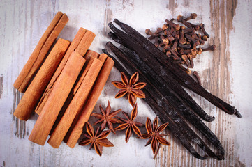 Cinnamon sticks, vanilla, star anise and cloves on wooden surface